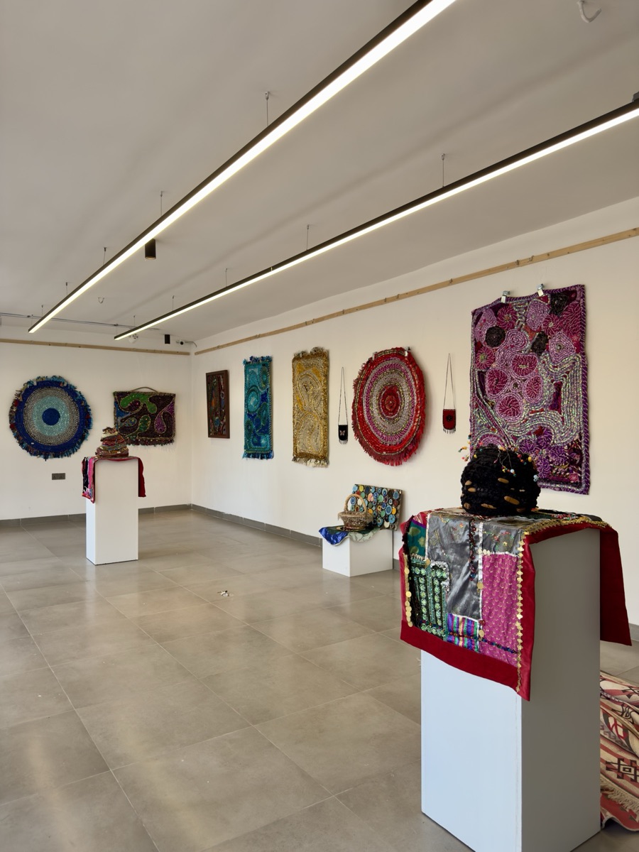 Exhibition hall with recycled rugs on the walls and pieces on plinths